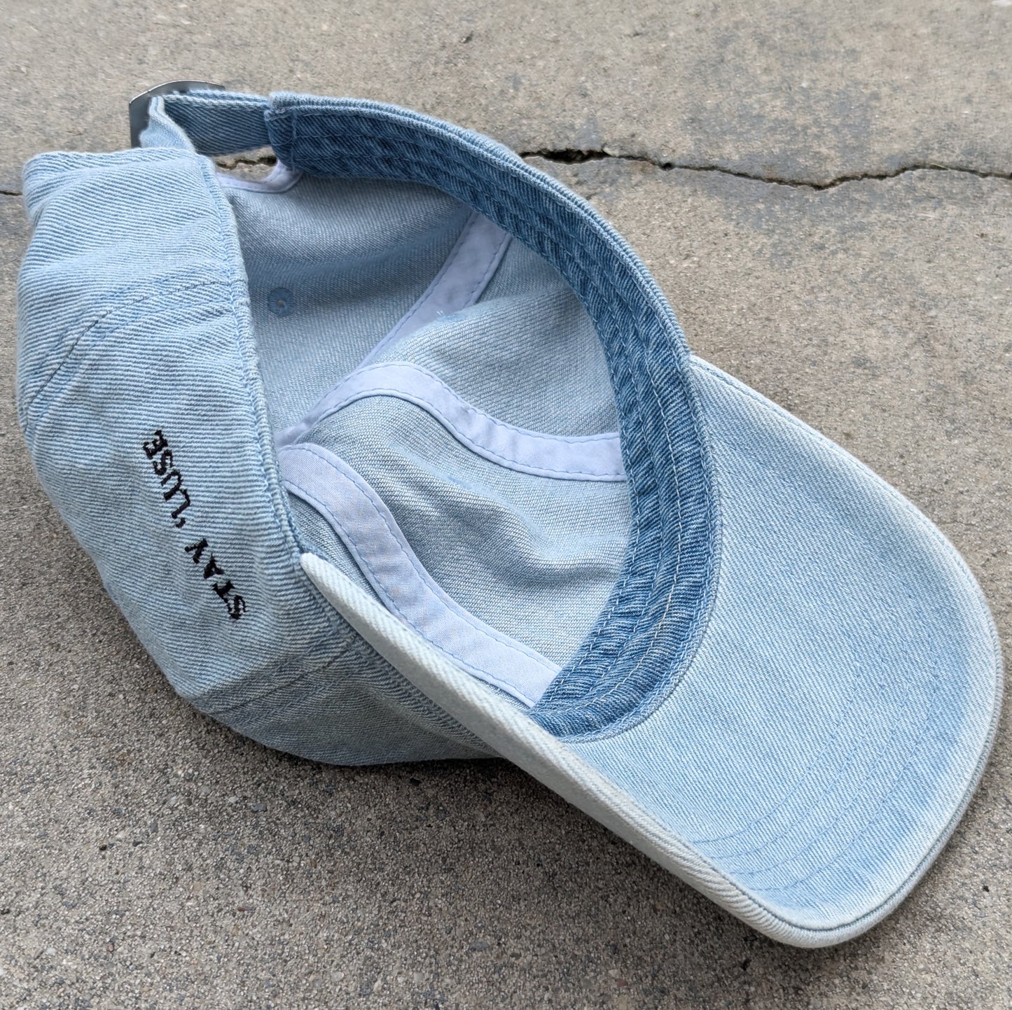 Stay 'luse denim hat in light blue. Stay 'luse embroidered on left side. Color-matched underside of brim.