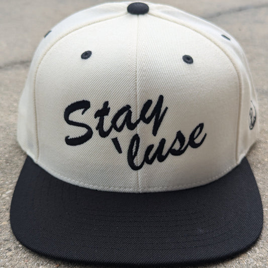 Stay 'luse Snapback in black and natural. Stay 'luse embroidered across the front in black.
