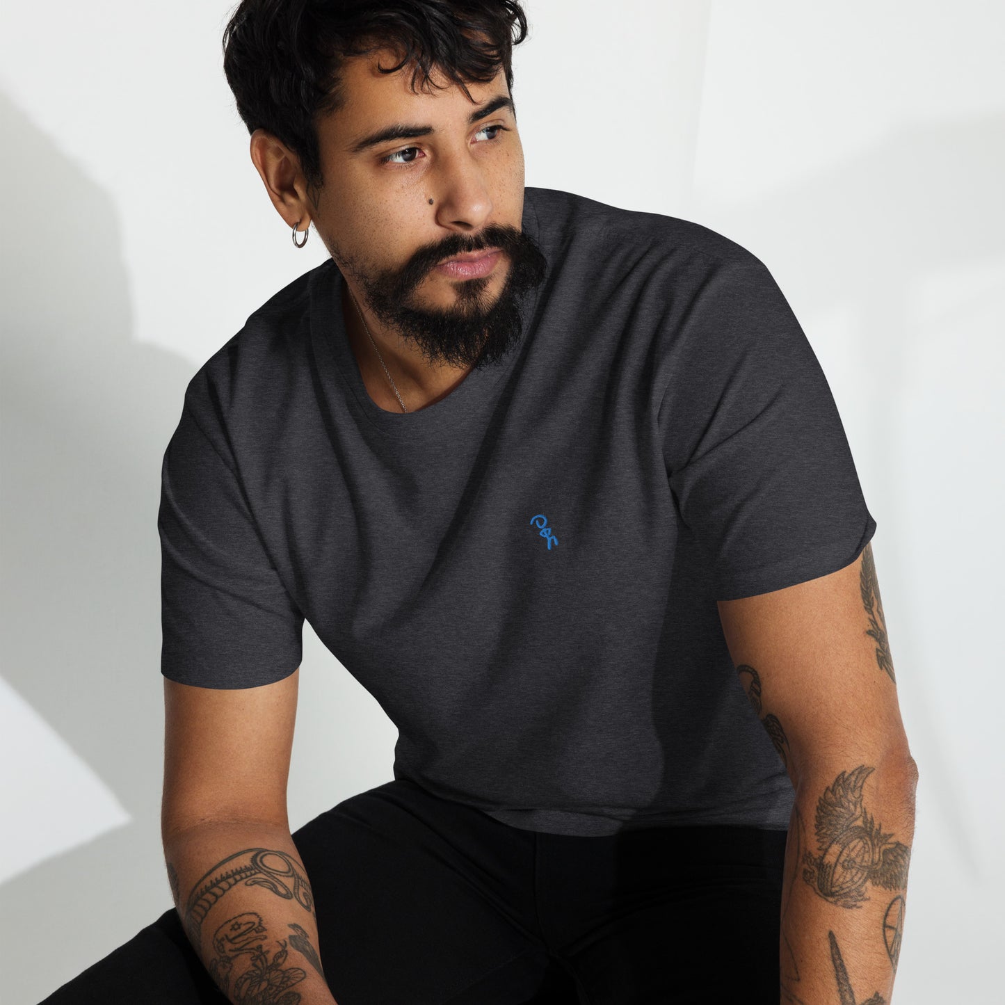 Man posing in premium charcoal heather t-shirt with blue Jaunty Man embroidered on left chest.