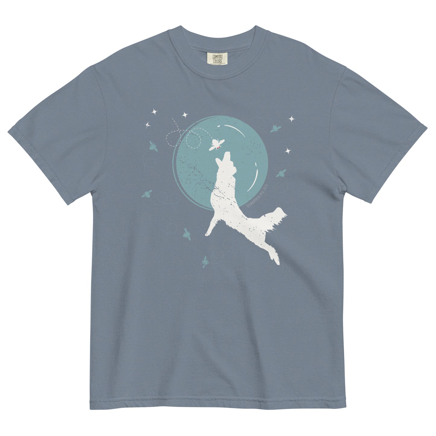 A gray blue short sleeved t-shirt laid flat. Front graphic features a silhouette of a dog jumping in front of a large, simplified moon to catch a cicada, while other cicadas flutter around the perimeter.