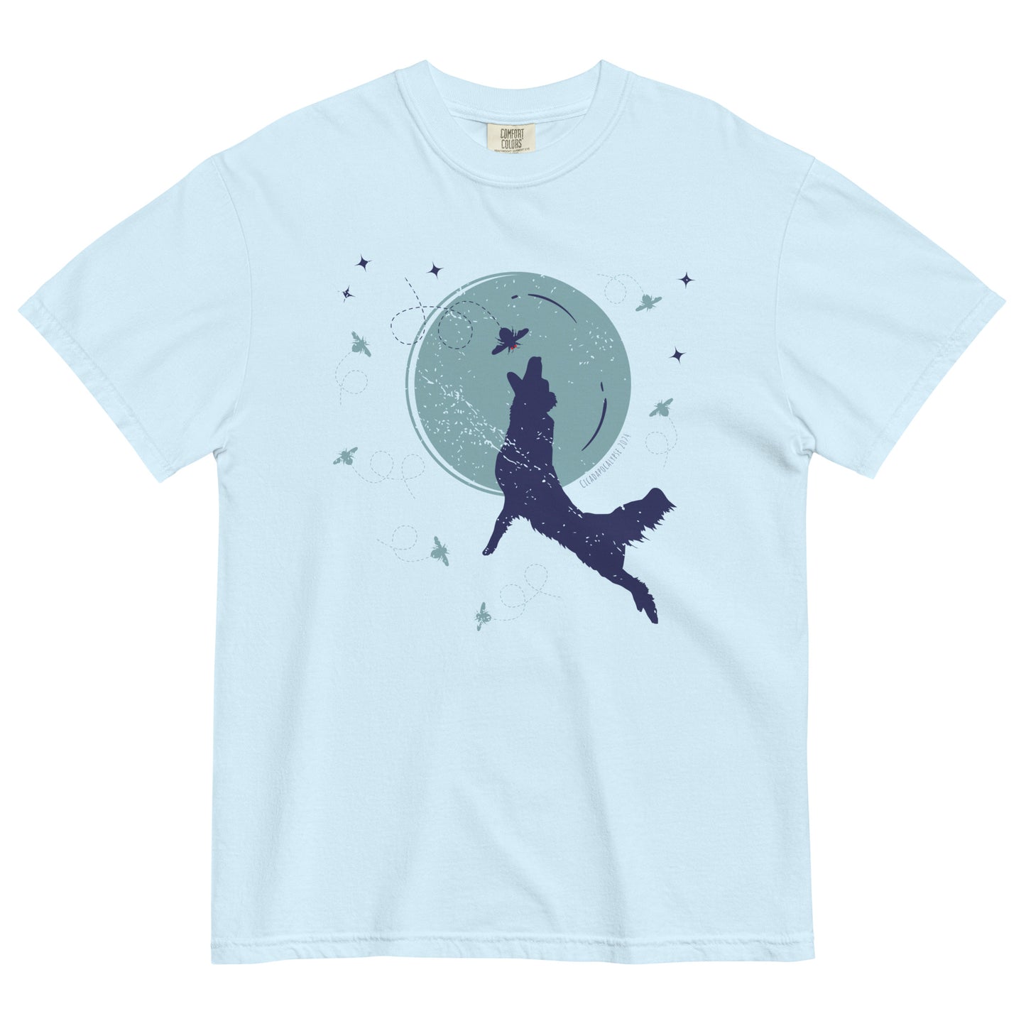 A light blue short sleeved t-shirt laid flat. Front graphic features a silhouette of a dog jumping in front of a large, simplified moon to catch a cicada, while other cicadas flutter around the perimeter.