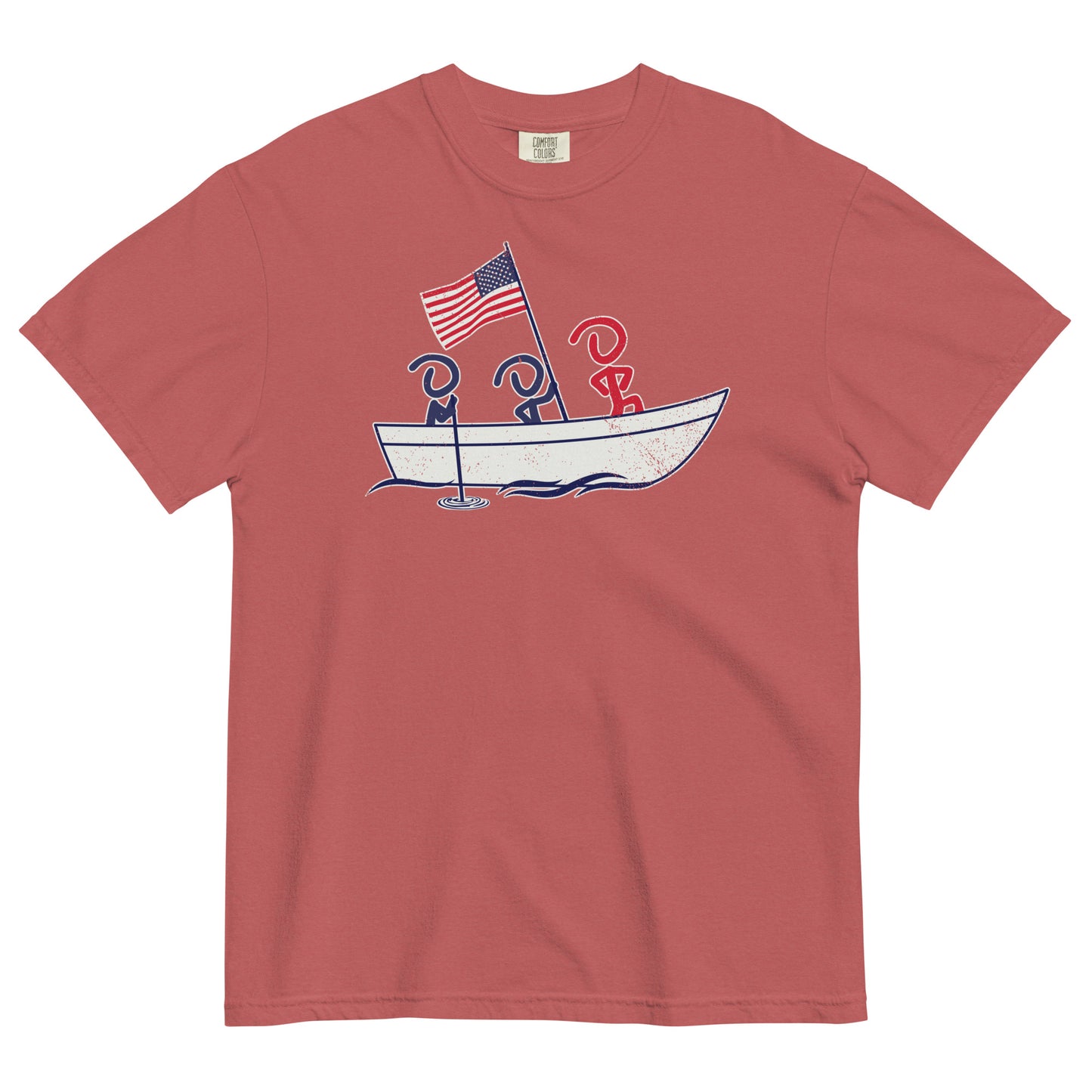 A red short sleeve t-shirt laid flat. Front graphic shows three Jaunty Men in a simple boat carrying an American flag, similar to George Washington crossing the Delaware.