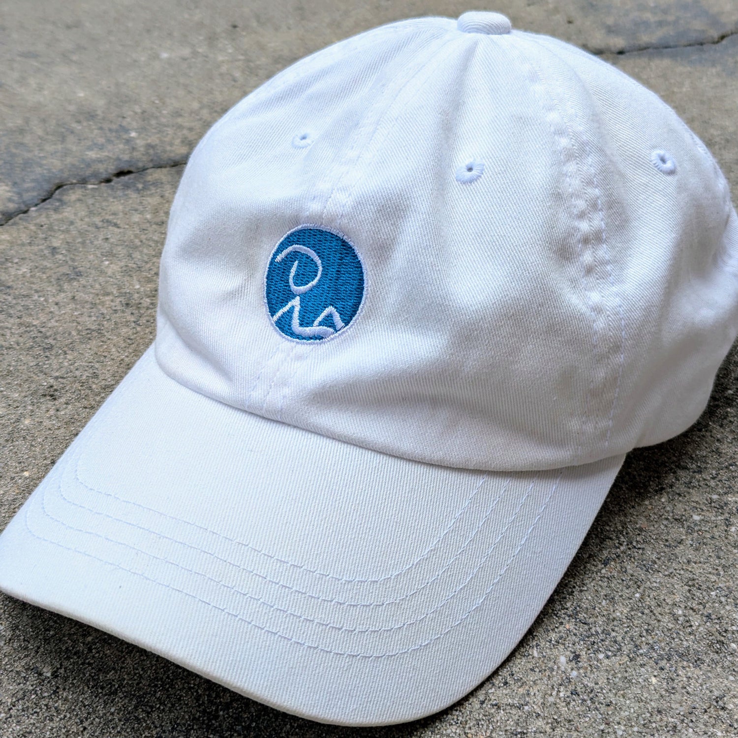 Classic dad hat in white. Recluse Rags logo without text in blue on front.