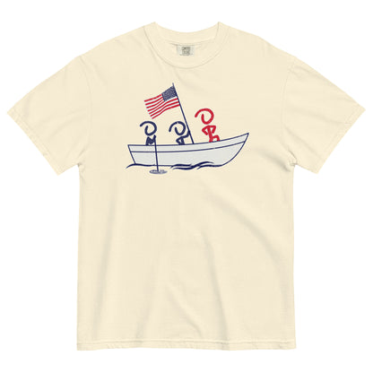 An ivory short sleeve t-shirt laid flat. Front graphic shows three Jaunty Men in a simple boat carrying an American flag, similar to George Washington crossing the Delaware.